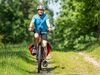 Mann mit Fahrradhelm und blauem T-Shirt fährt Mountainbike auf einem Waldweg im Naturschutzgebiet Lüneburger Heide bei ispingen